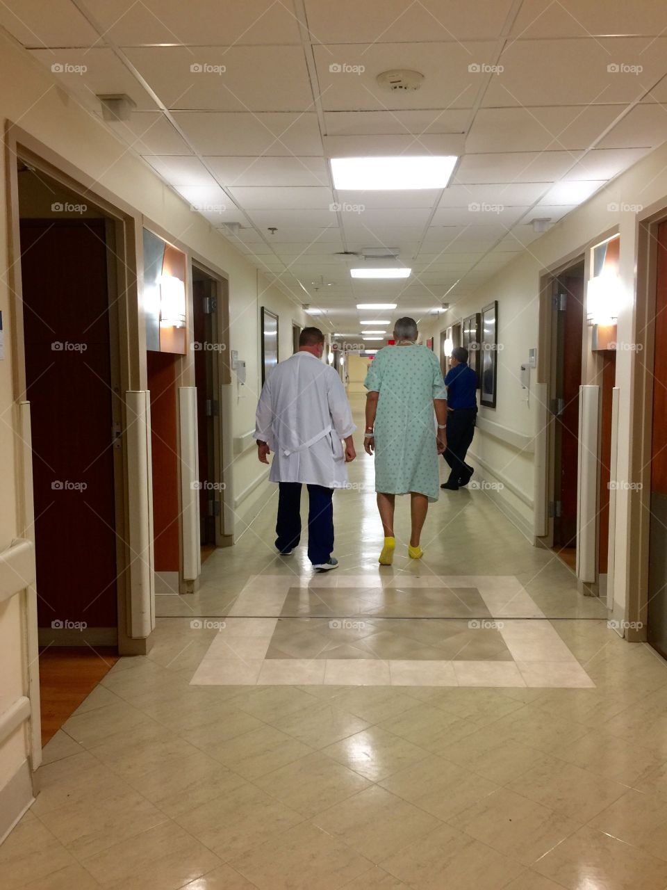 Doctor and patient walking on hallway of hospital