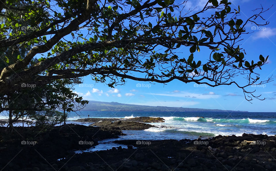 Volcano rising out of the ocean at a distance