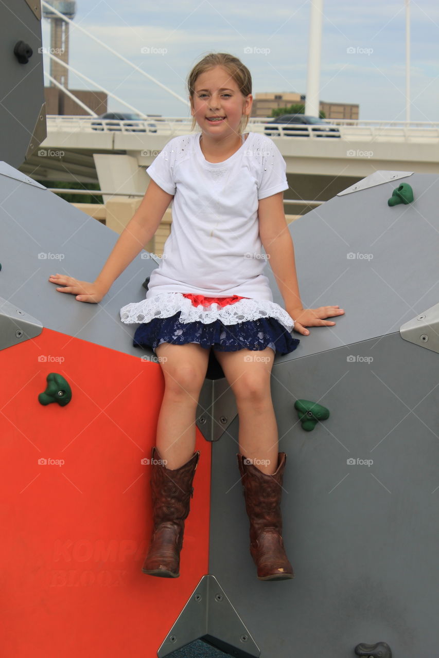 Climb up to pose. Girl who rock climbed up for a photo op