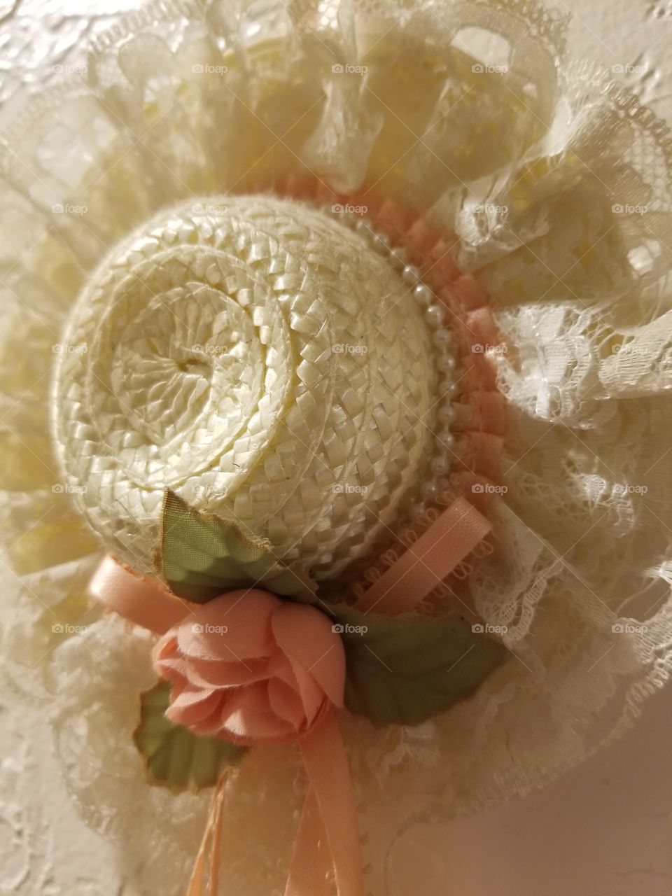 peach rose and lace adorn a straw woven hat, close up,  cute but delicate