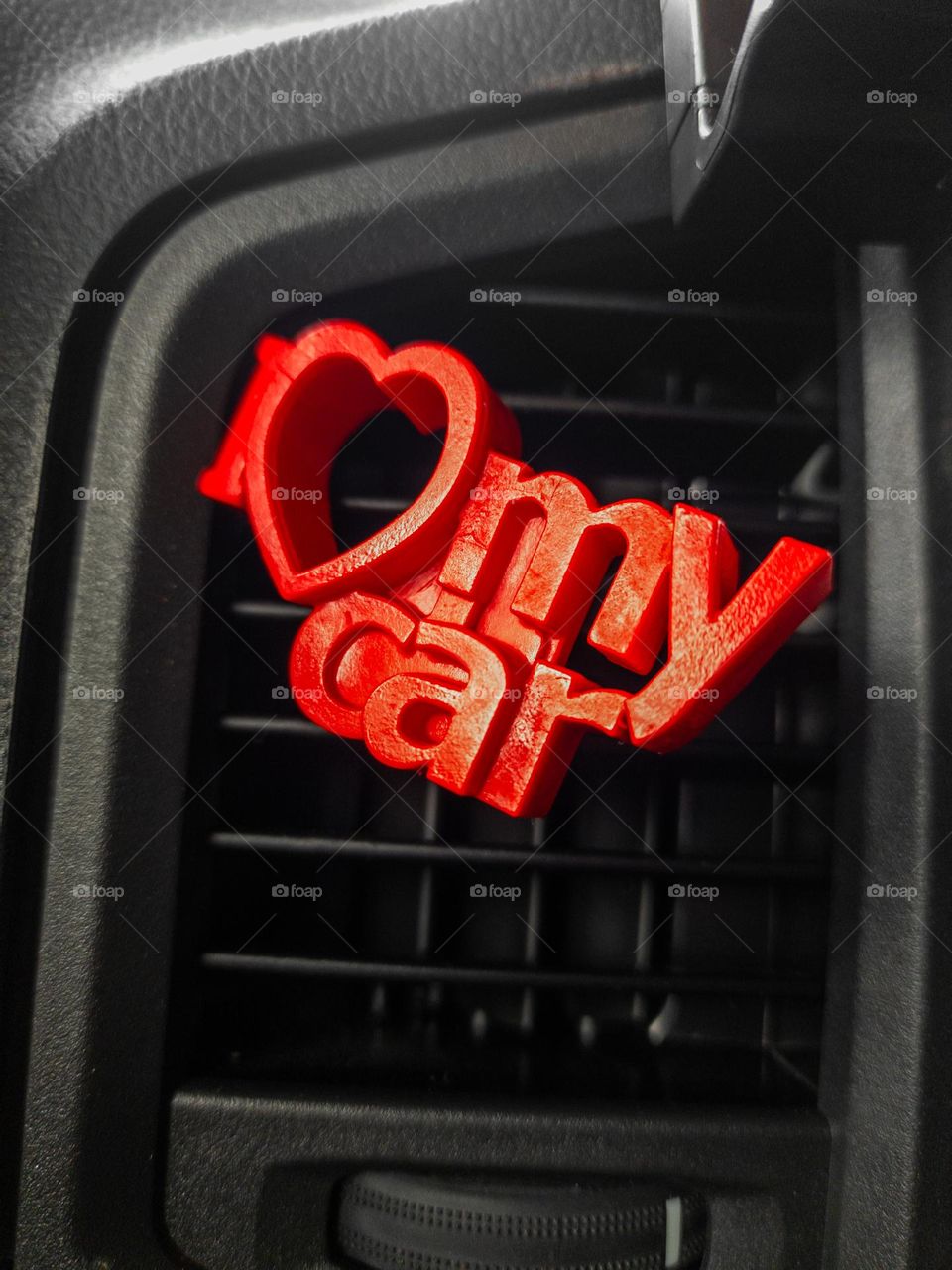 a red sign in a car placed on the air vent