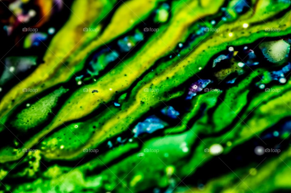 The ink to refill the printer cartridge was spilled onto the white washbasin and the paints blended into abstract drips and patterns