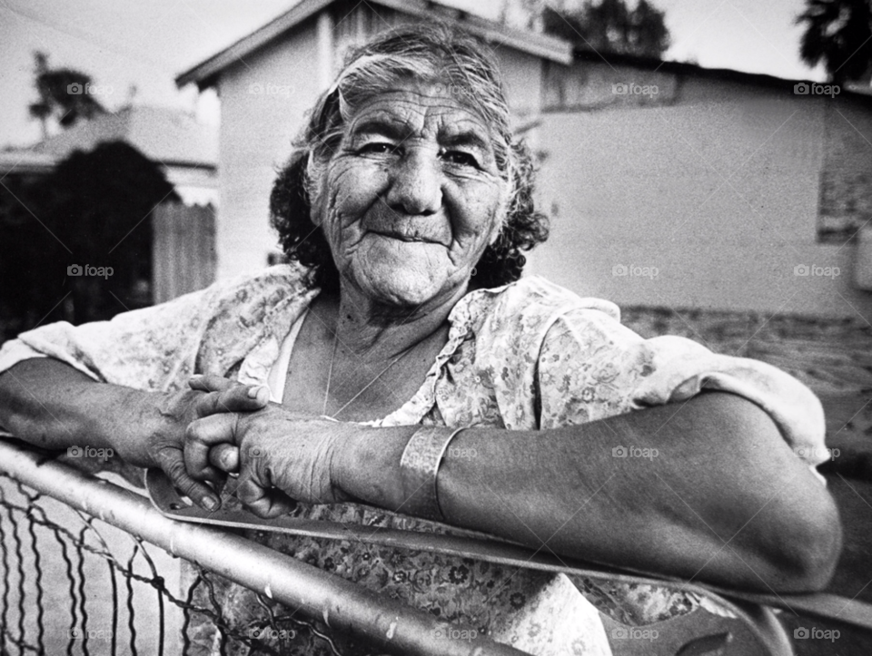 phoenix arizona an old woman poses at her front yard gate. in a hispanic neighborhood in phoenix az by arizphotog