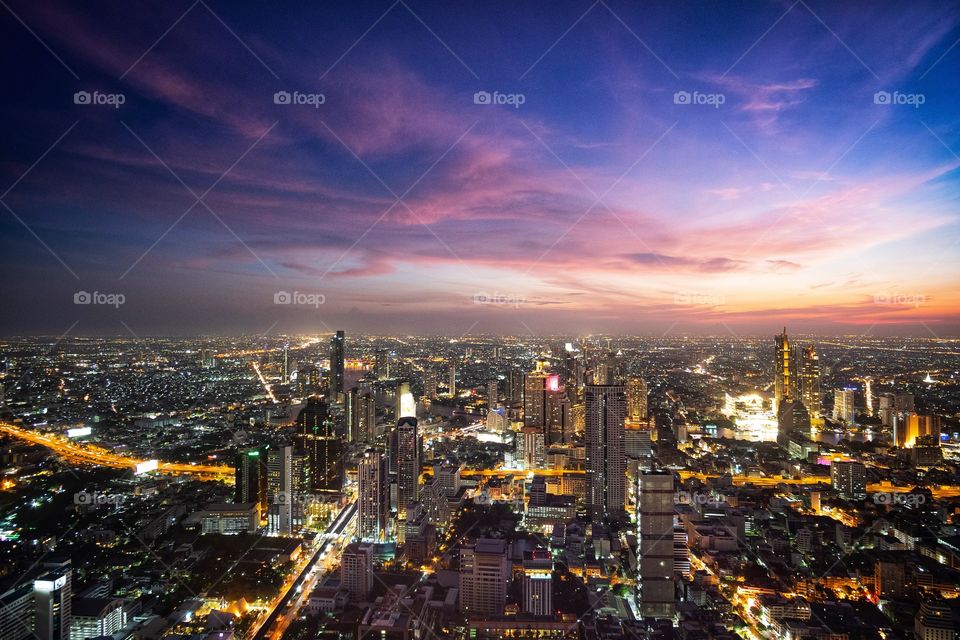 Sun set over capital city Bangkok Thailand from roof top Mahanakorn Building