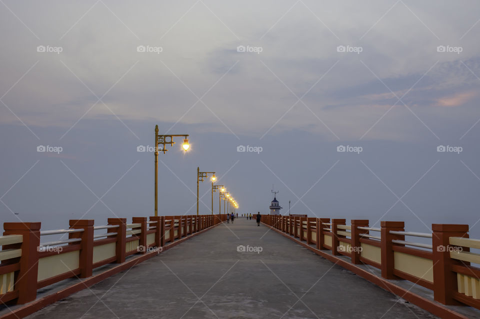 The lights on the bridge and the people running exercise at Prachuap Bay in Thailand.