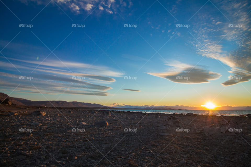 rocks and sand beach near andes mountains and argentina lake