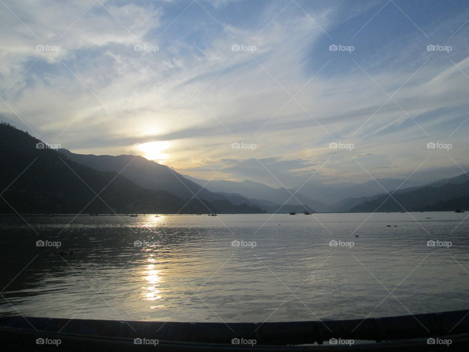 Beautiful lake with boats during sunset surrounded by Himalaya mountains