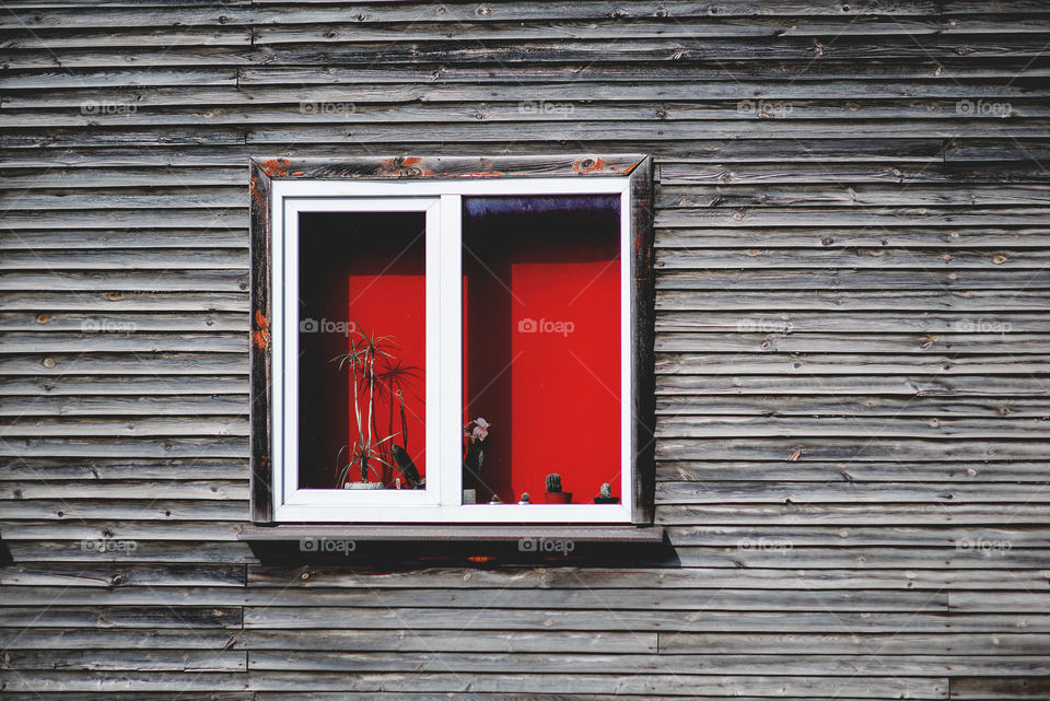 Red window on wooden wall