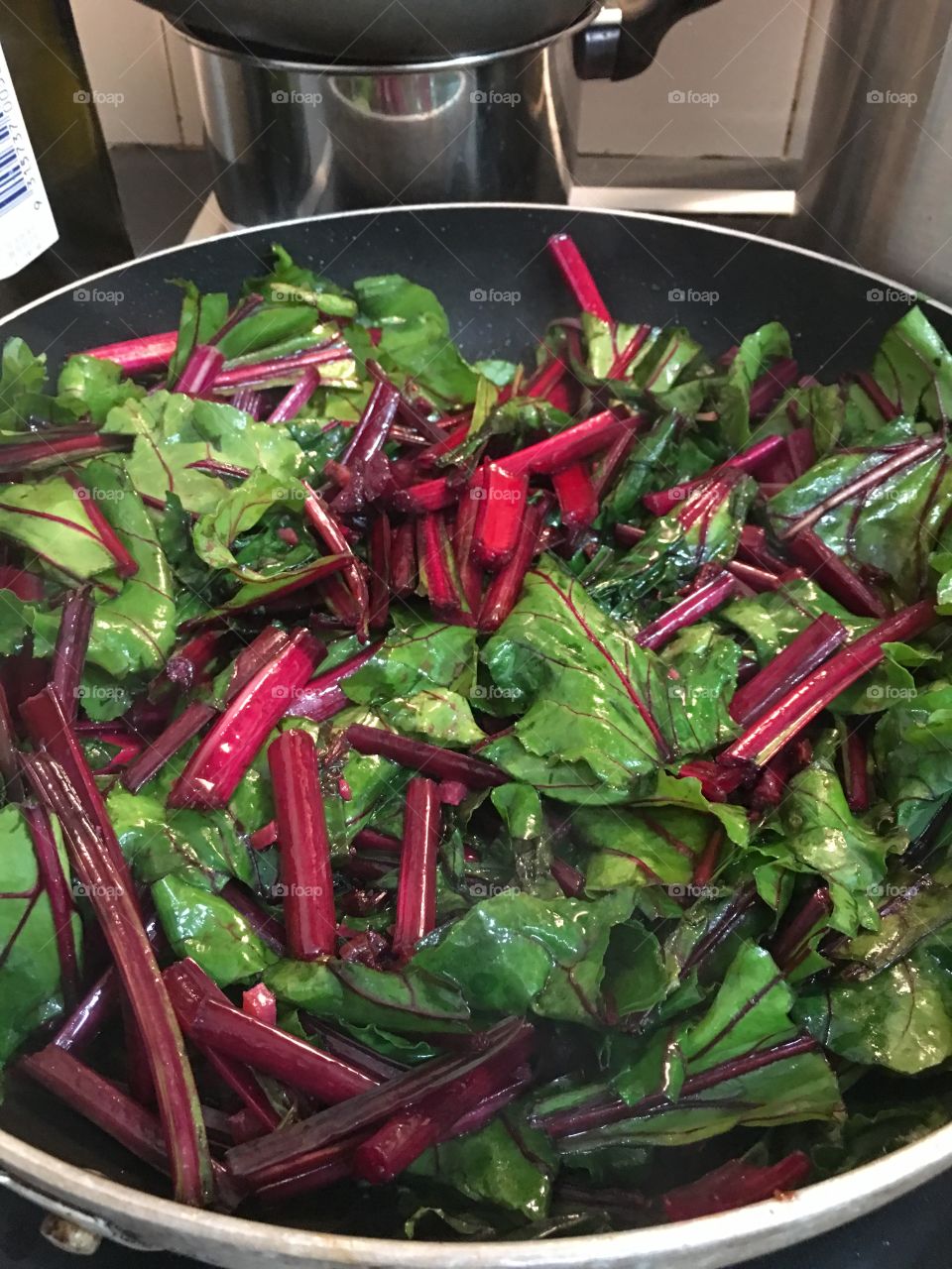 Healthy eating, bright beautiful greens and reds, beet root beet greens closeup in cooking pan healthy cooking eating and nutrition 