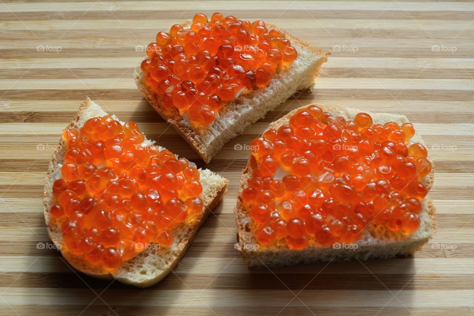 sandwiches with red caviar wood table background