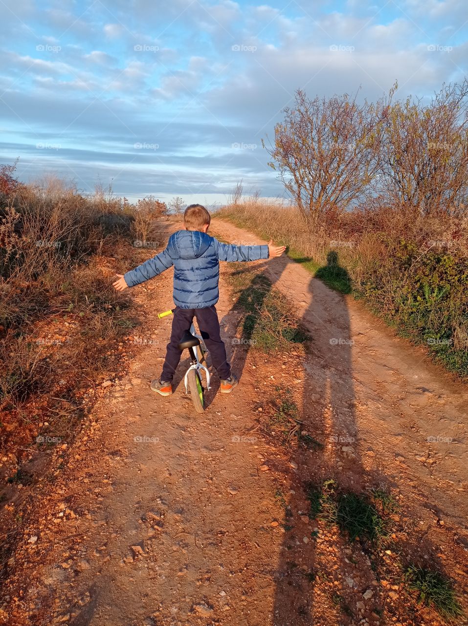 Making an airplane. A kid with open arms in the middle of the road.