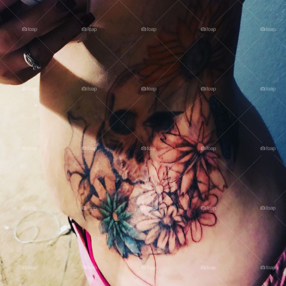 Flower and skull side tattoo