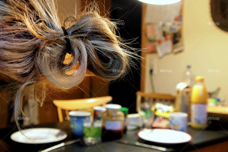 Breakfast table in kitchen with hair bun in foreground