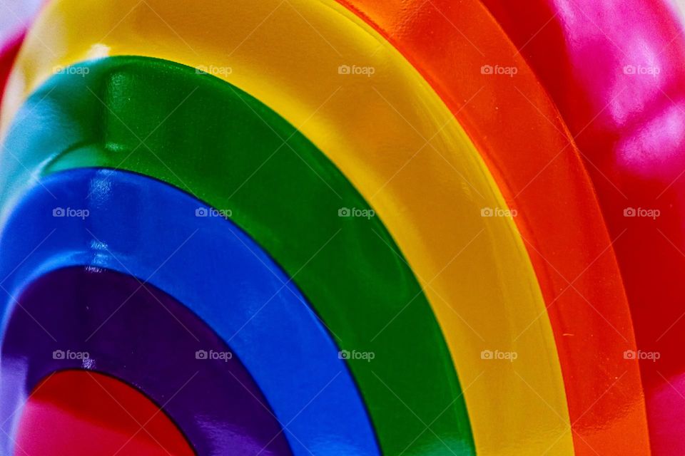 The colors of the rainbow on a coffee mug, bright and vibrant just like the colors of the gay pride flag 