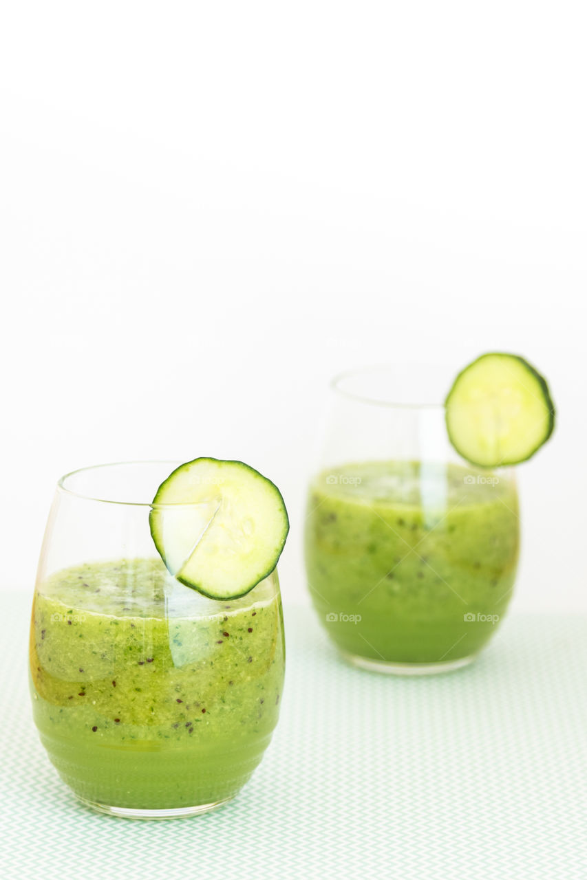 two green smoothies made with cucumber, green pepper, lemon juice and kiwi
