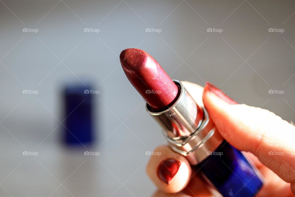 Woman's hand is holding a lipstick