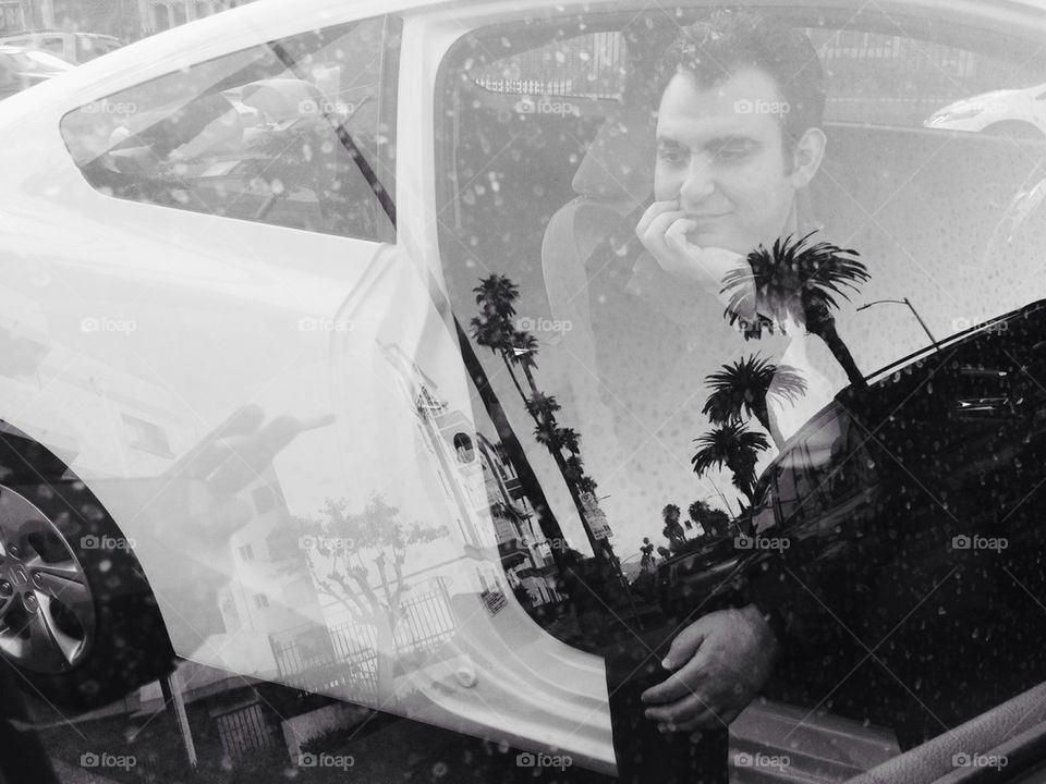Man in car   palm tree reflection