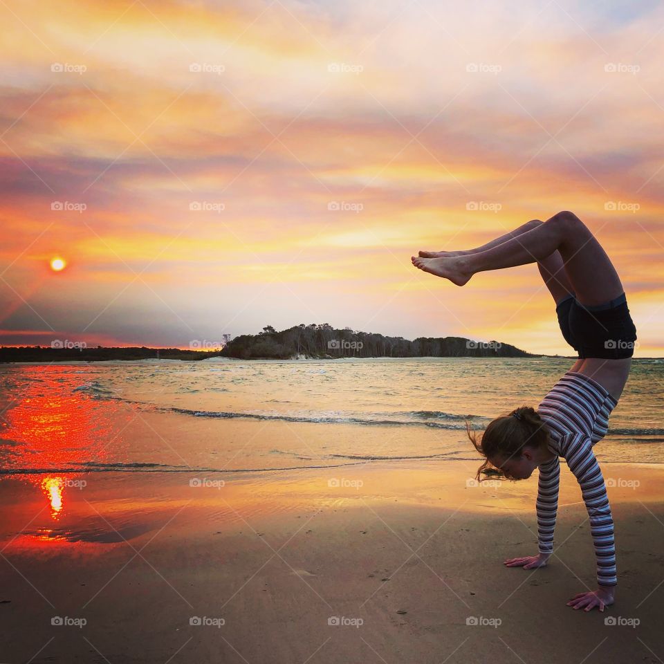 Yoga at the beach at sunset red skies pink sun