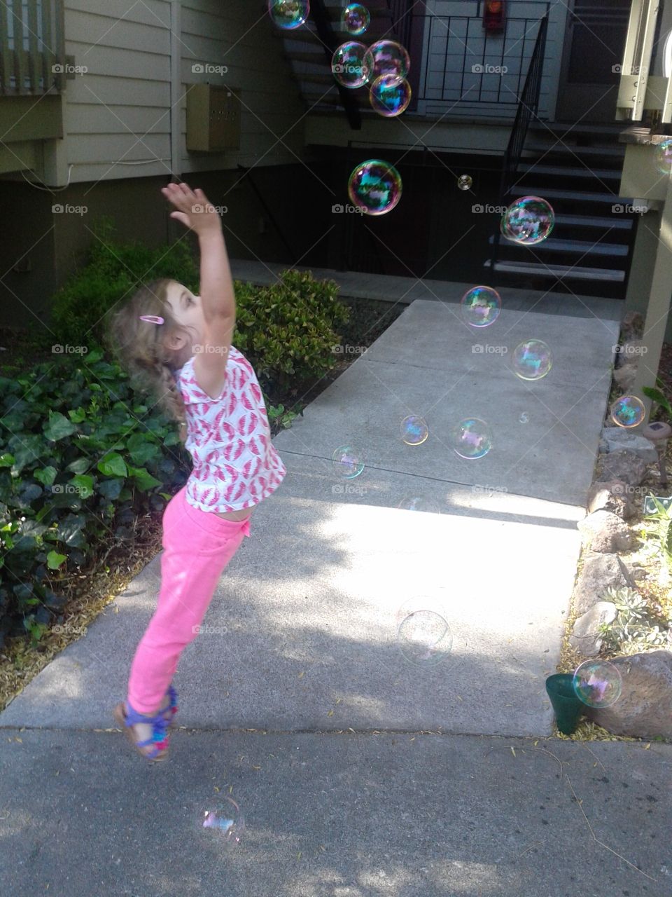 A little girl playing with soap bubbles