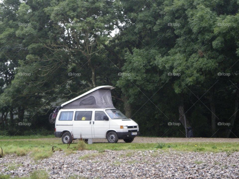 Vintage VW camping car on a beach in Denmark with forest as background 