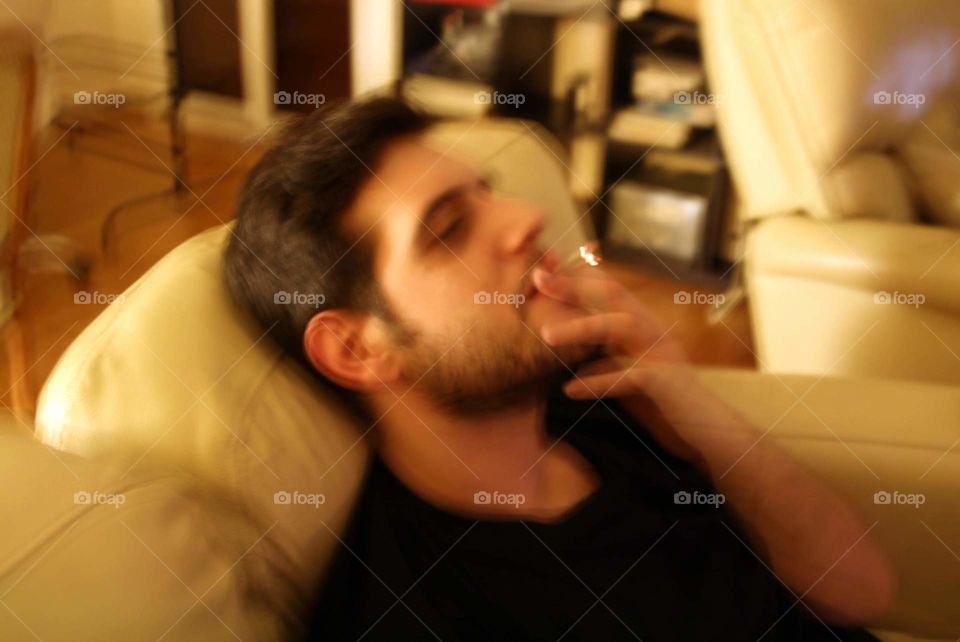 handsome man sitting in sofa smoking
