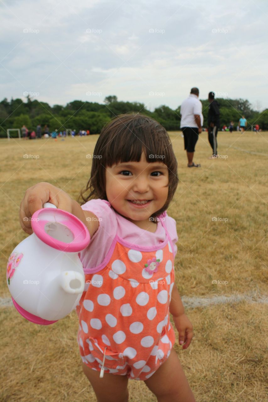 Portrait of cute girl holding teapot