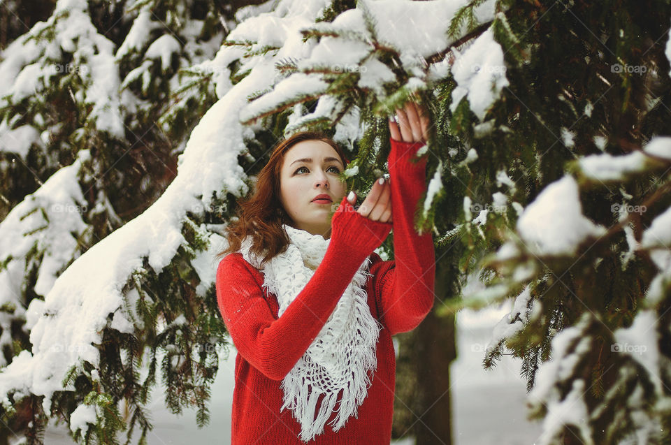 Portrait of young redhead woman walking and enjoying in snowcovered winter park. Lifetime. Holidays time.