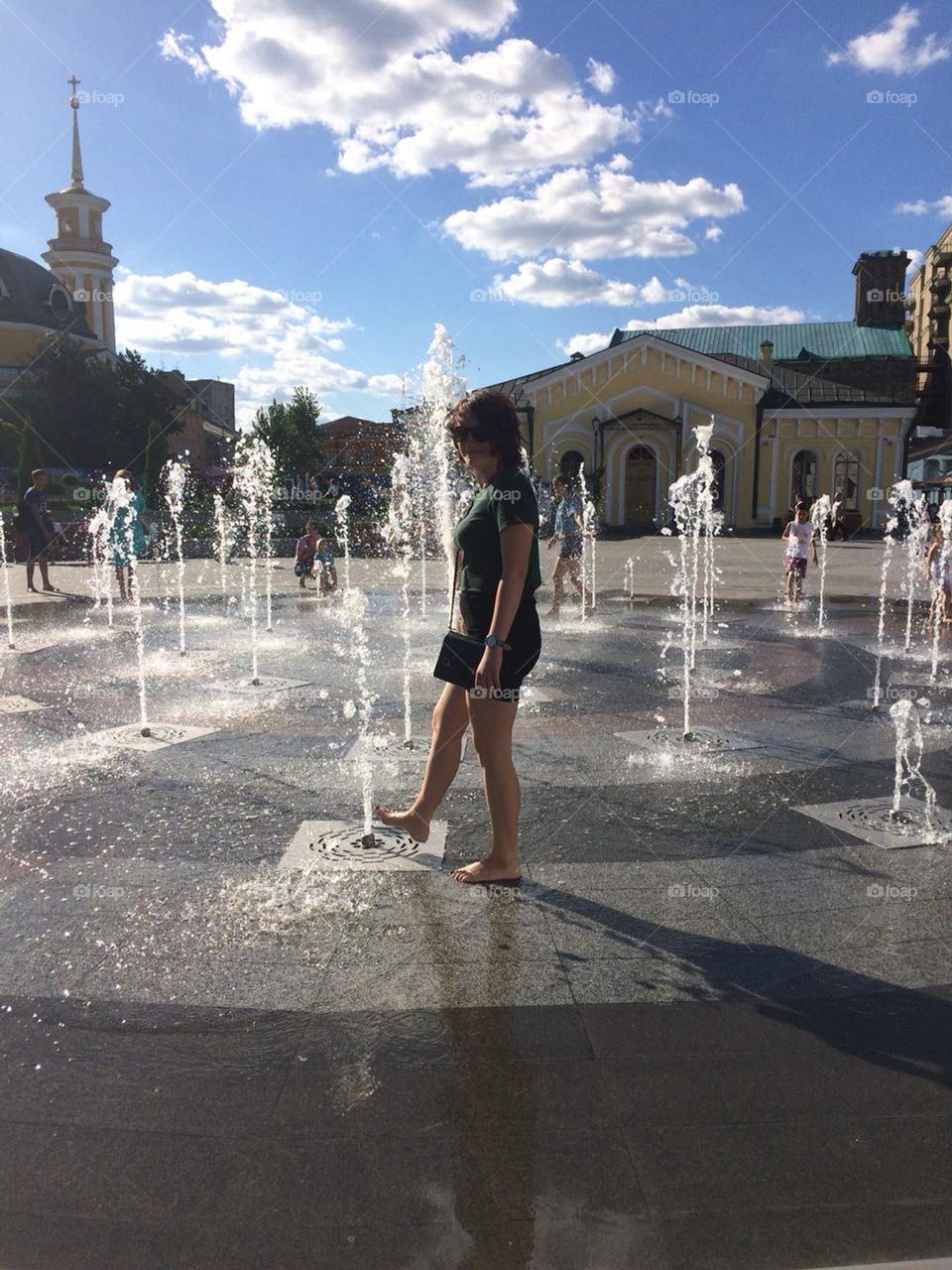 Girl bathing in a city fountain in summer