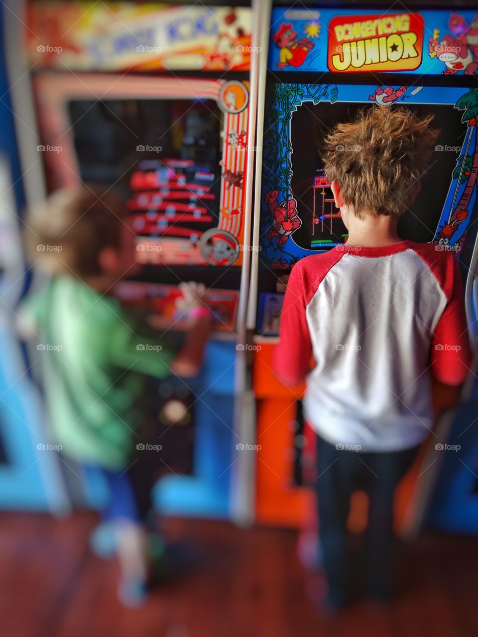 1980s Arcade Videogames. Children Playing Videogames In A Retro 1980s Arcade
