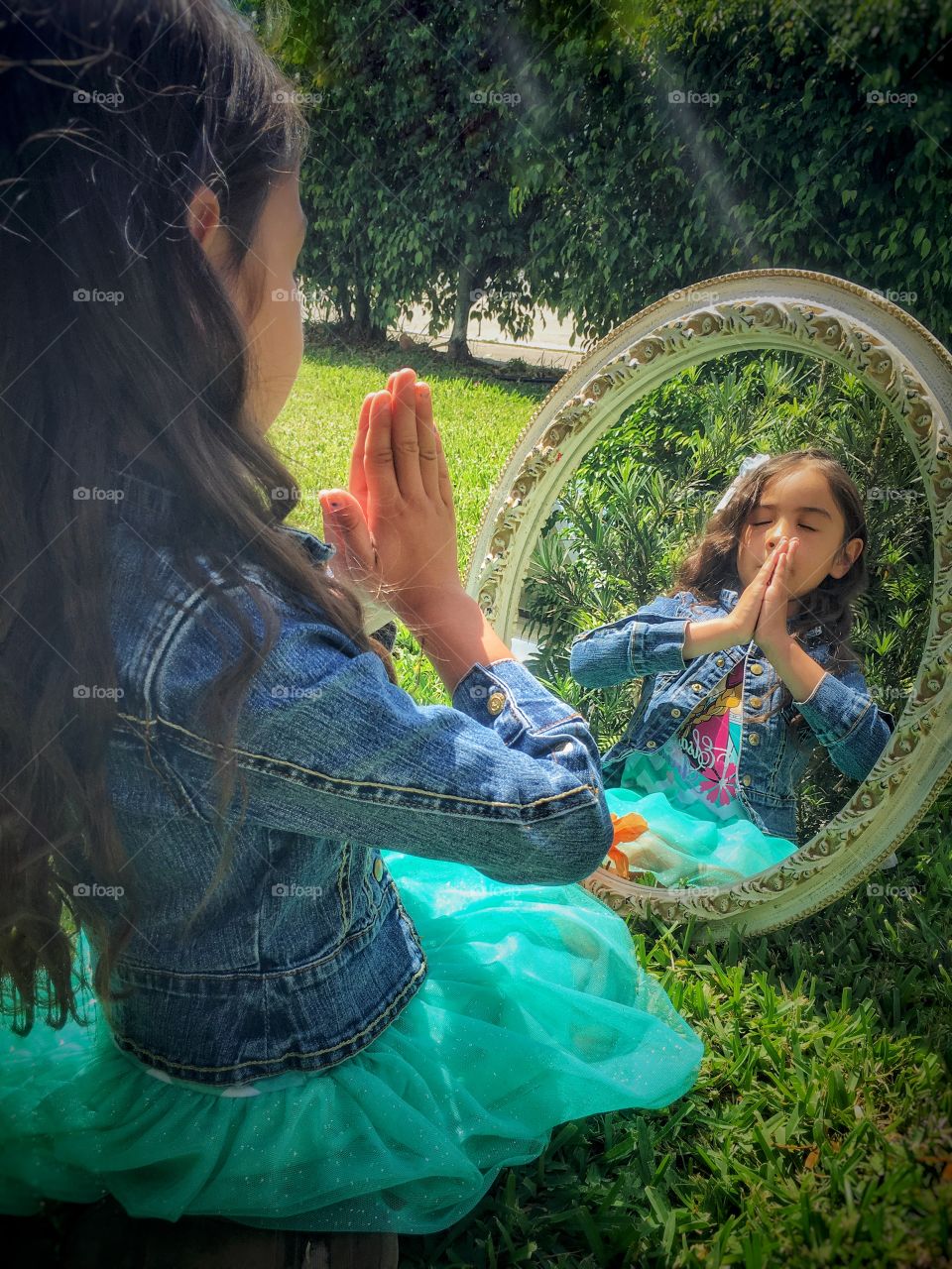 Reflection of girl in mirror praying