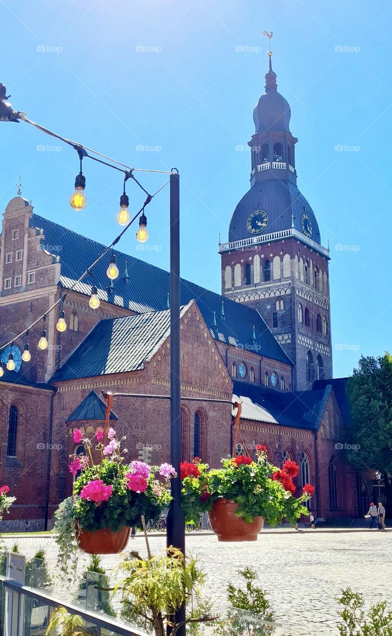 cityscape, bright flowers and garland against the backdrop of a medieval church, Riga, Latvia