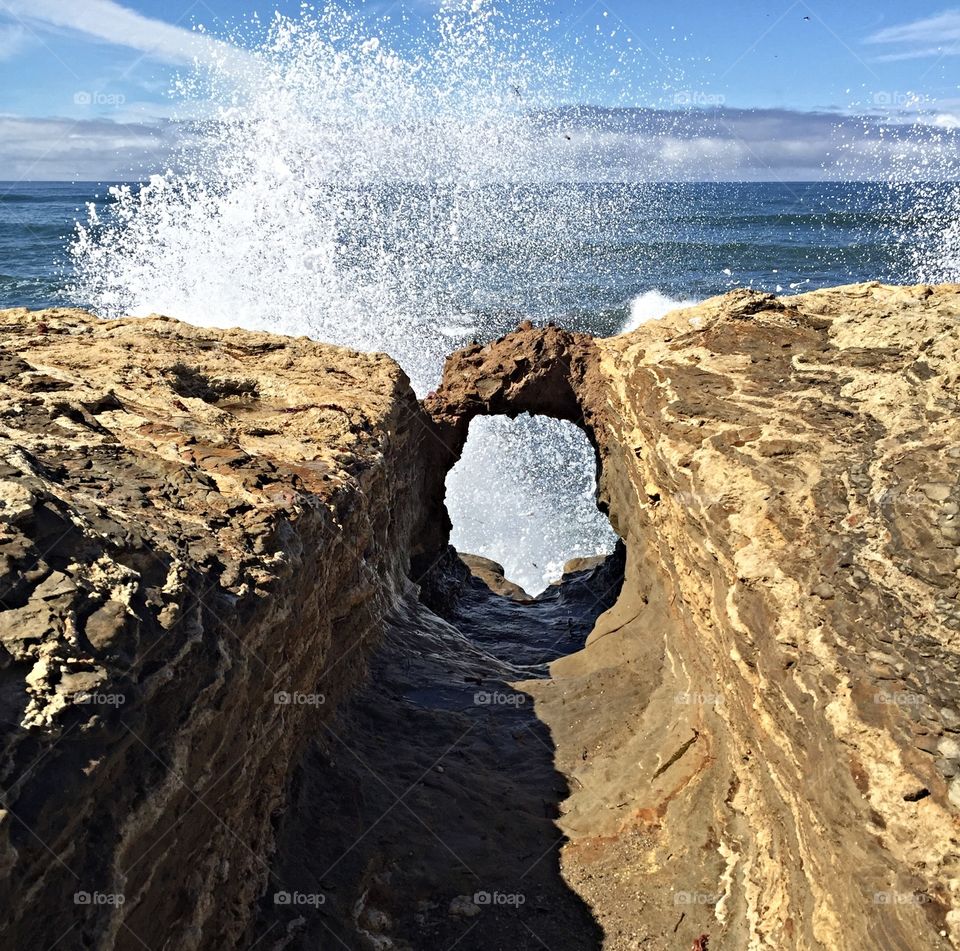 Scenic view of waves breaking rock
