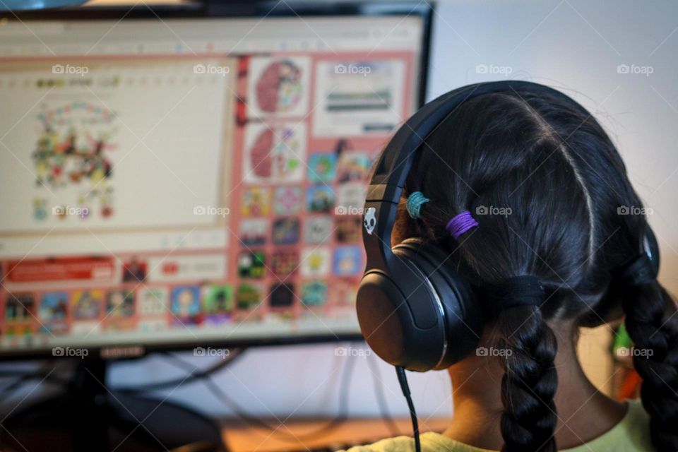 Cute girl is playing video games on a computer