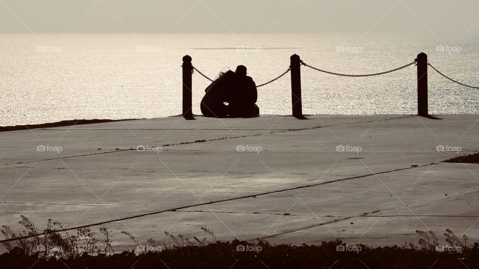 A candid shot of a couple looking towards the ocean waters. 