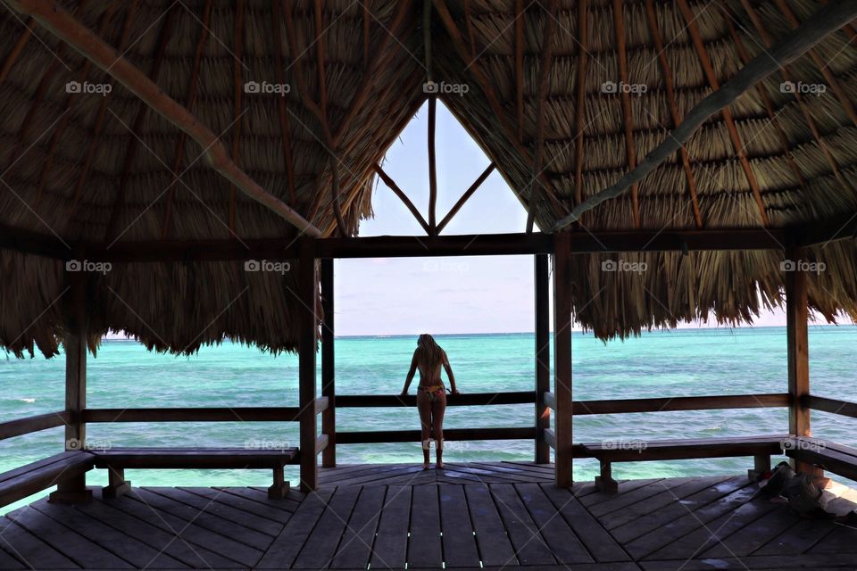 Girl in palapa looking at ocean