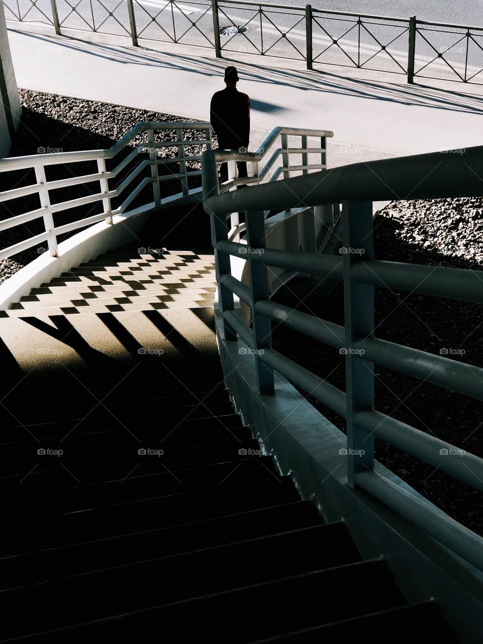 Unrecognisable man walking down stairs on a sunny day