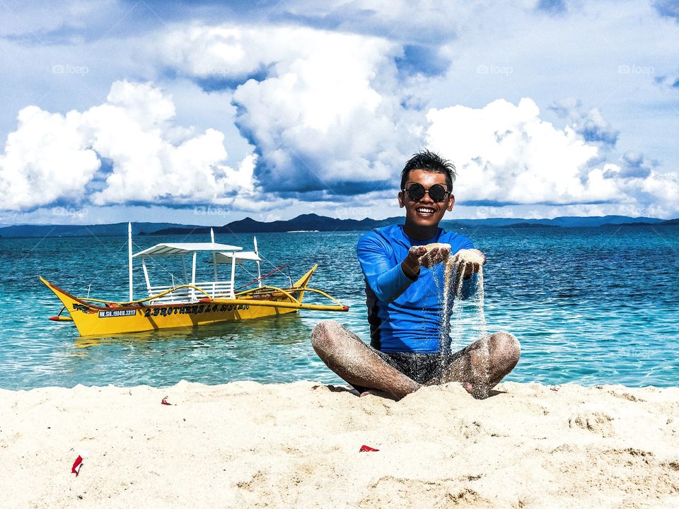 A young guy playing sand at the beach