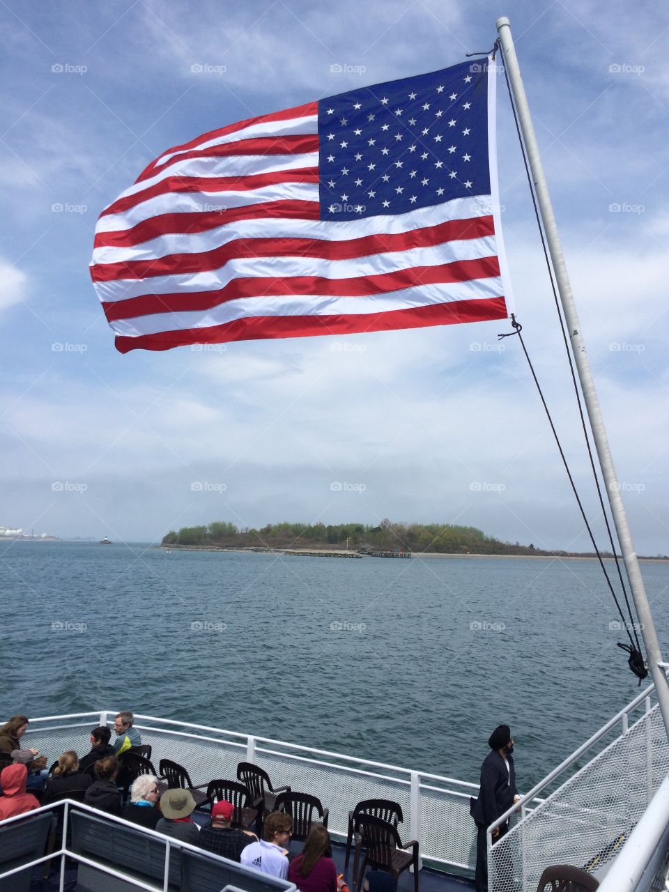 American flag on boat. Island in the background 