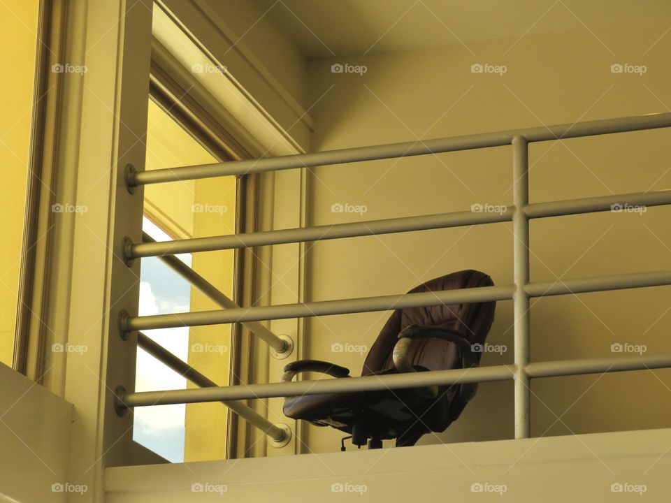 Office Chair Facing Large Window on an Upper Level