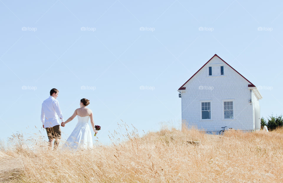 Two if by sea #marriage #wedding #ido #manandwife #islandwedding #nuptials #whitedress #bride #groom #love  #cliff #grass #whitedress #holdinghands #house #cabin #cottage 