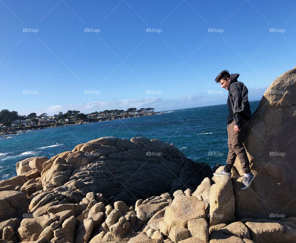 Boy standing at the edge of cliff
