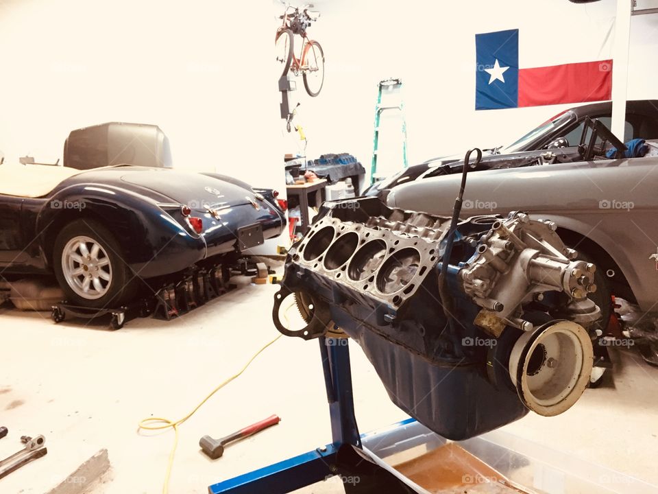 Working on classic cars in garage, disassembled engine 