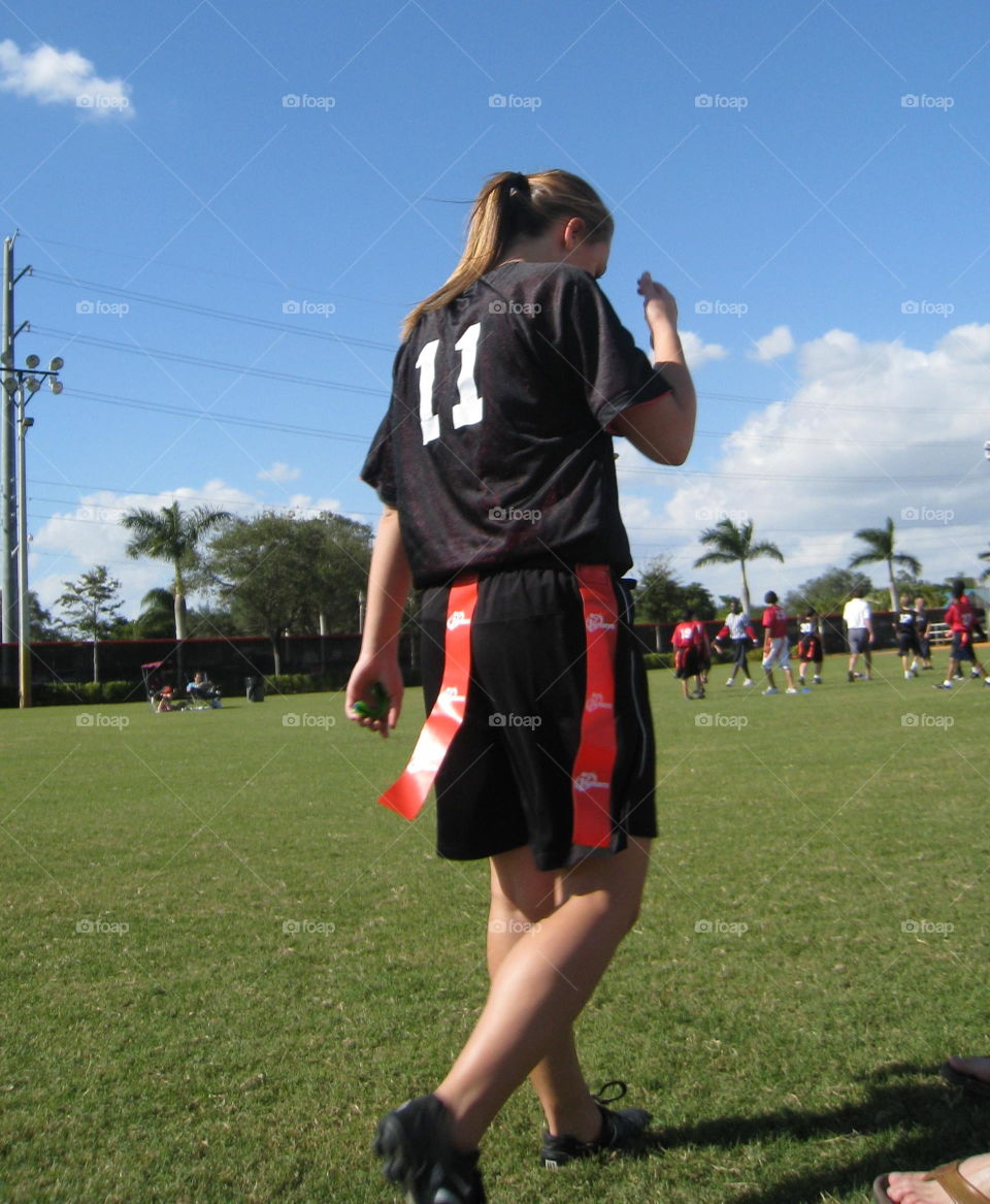 Girl game on. Girl playing flag football with a team of all boys. Walking onto the field
