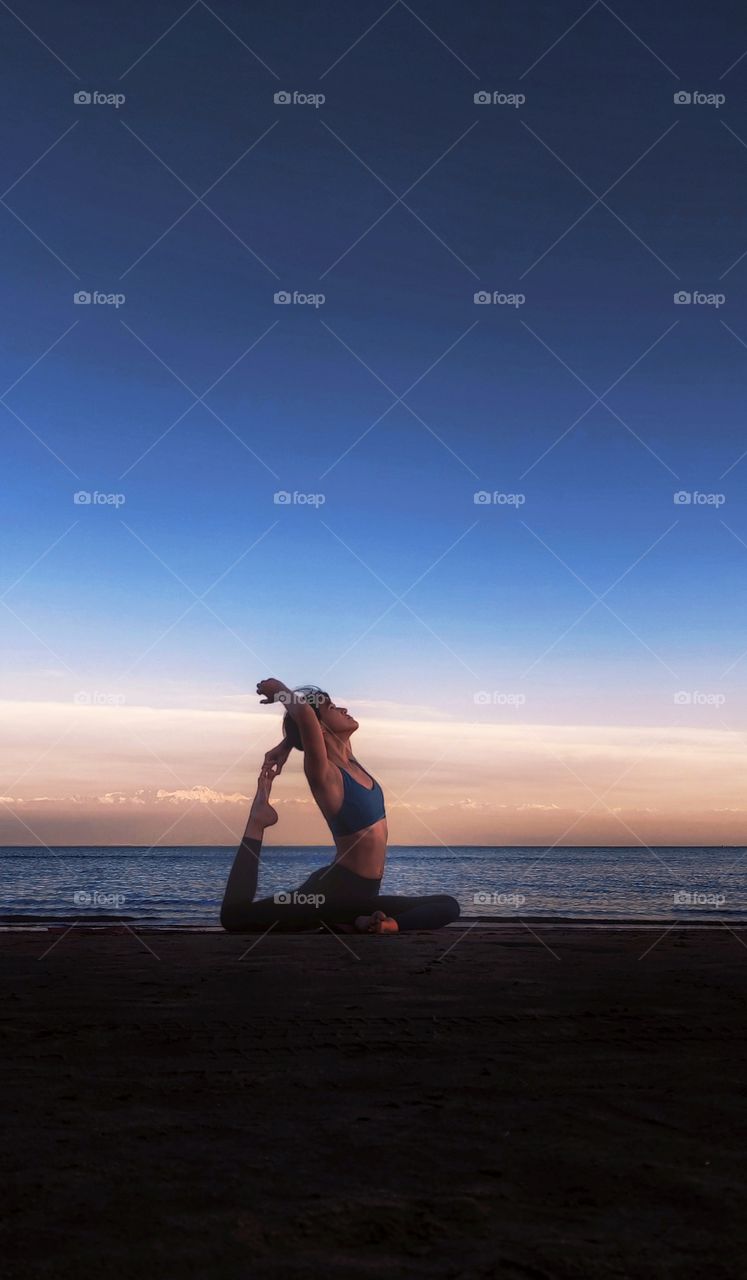 The girl is engaged in yoga in the evening by the lake.Foap mission evening story.
