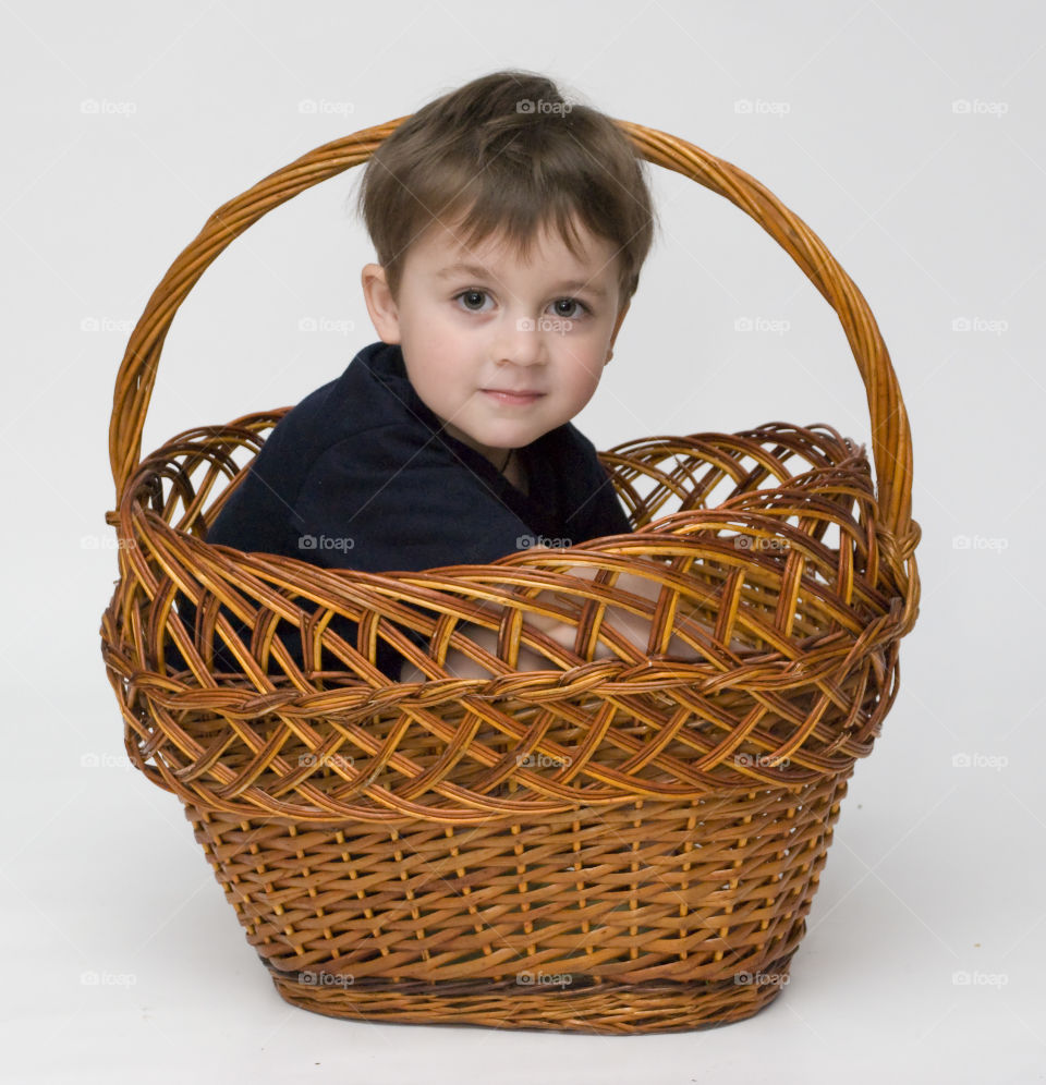 Boy sitting in wicker basket