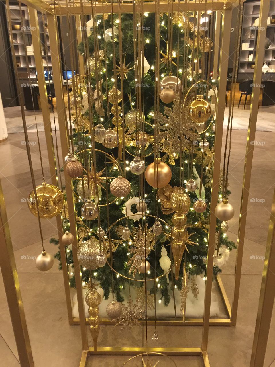 Christmas ornaments hanging separately in front of decorated Christmas tree however together looks like a cool effect