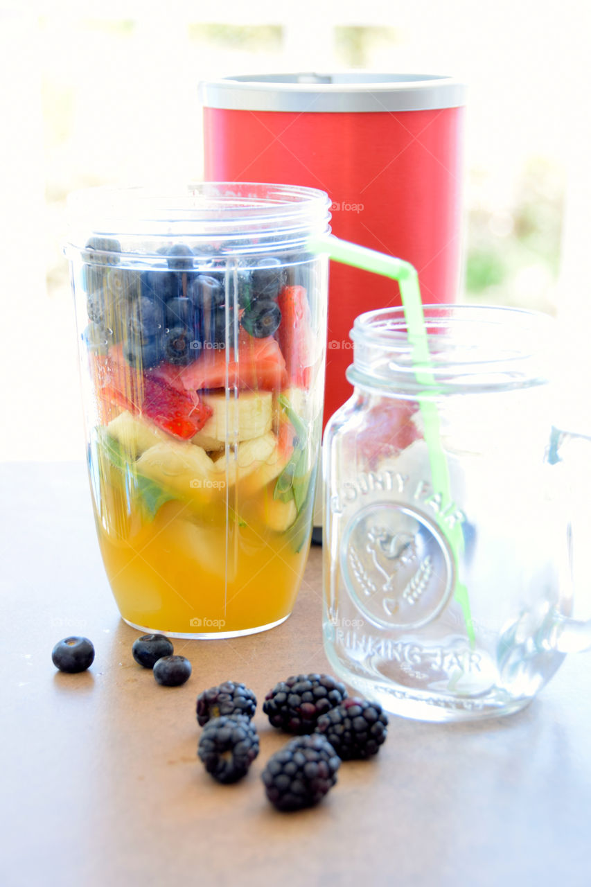 Healthy fruit smoothie of spinach pineapple blueberries strawberries banana and orange