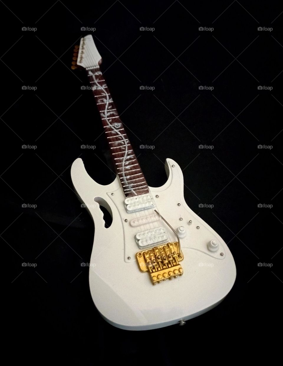 Miniature guitar in dark background