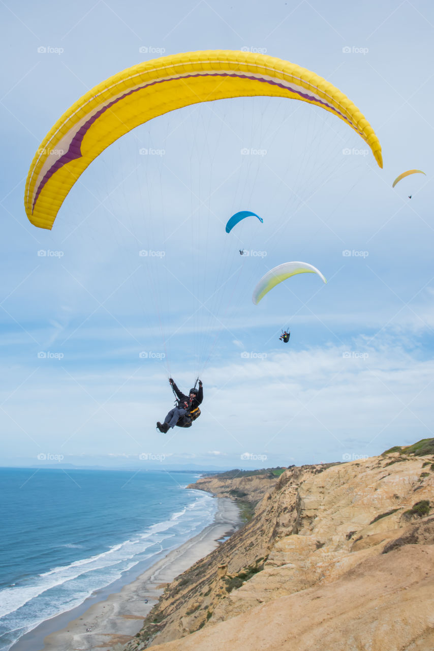 Paragliders soar over the San Diego coastline