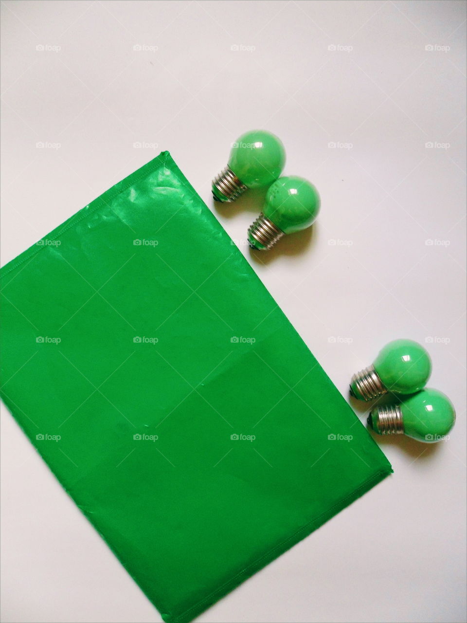 Green light bulbs and a green folder for documents